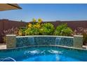 Inviting pool with a waterfall feature, surrounded by lush landscaping at 25546 N 164Th Dr, Surprise, AZ 85387