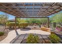 Inviting covered patio with a decorative pergola, seating, and manicured landscaping at 26333 W Vista North Dr, Buckeye, AZ 85396