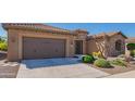 Front exterior featuring desert landscaping, and a brown two-car garage at 26333 W Vista North Dr, Buckeye, AZ 85396
