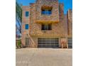 Front exterior view of modern multi-story townhome with stone accents, garage and neutral color scheme at 312 S Hardy Dr # 106, Tempe, AZ 85281