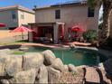 Inviting backyard with a refreshing pool, covered patio, and lush landscaping at 45722 W Barbara Ln, Maricopa, AZ 85139