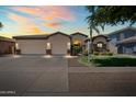 Charming single-story home featuring a spacious three car garage, manicured lawn, and stone accents at 4614 E Reins Rd, Gilbert, AZ 85297