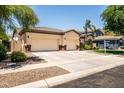 Charming single-story home featuring a spacious three car garage, manicured lawn, and stone accents at 4614 E Reins Rd, Gilbert, AZ 85297