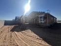 Home under construction with window frames, roof framing, and an open yard at 47437 W Kenner Dr, Maricopa, AZ 85139