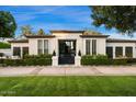 Beautiful home showcasing a well-maintained lawn, manicured landscaping, and black framed windows at 5700 E Sanna St, Paradise Valley, AZ 85253
