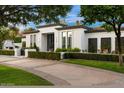 Beautiful home showcasing a well-maintained lawn, manicured landscaping, and black framed windows at 5700 E Sanna St, Paradise Valley, AZ 85253