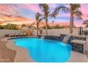 Beautiful pool with dual waterfalls, framed by lush landscaping and a serene ambiance at twilight at 5941 S Cambridge St, Chandler, AZ 85249