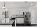 Bright kitchen with stainless steel refrigerator, granite counters, and mosaic backsplash at 9631 E Palm Ridge Dr, Scottsdale, AZ 85260