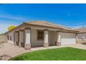 Inviting single-story home with lush green lawn, a two-car garage, and a charming covered porch at 10212 E Caballero St, Mesa, AZ 85207