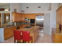 Well-lit kitchen boasts granite countertops, stainless steel appliances, and a large center island at 11290 N 117Th St, Scottsdale, AZ 85259