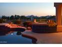 Pool with tiled spa and built in grill on patio with mountain views at sunset at 11290 N 117Th St, Scottsdale, AZ 85259