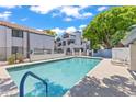 Community pool area with clear blue water, lounge chairs, and manicured landscaping at 1800 W Elliot Rd # 240, Chandler, AZ 85224