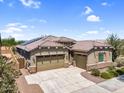 Charming single-story home featuring a three-car garage, solar panels, neutral paint, and well-manicured landscaping at 21352 E Domingo Rd, Queen Creek, AZ 85142