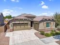 Charming single-story home featuring a three-car garage, neutral paint, stone accents, and well-manicured landscaping at 21352 E Domingo Rd, Queen Creek, AZ 85142