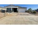 Picture of a single Gathering home still under construction with a two car garage and desert landscaping at 22669 E Saddle Way, Queen Creek, AZ 85142