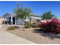 Beautiful single Gathering home with a two-car garage and desert landscaping with mature trees and bougainvillea bushes at 22669 E Saddle Way, Queen Creek, AZ 85142