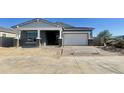 New construction exterior elevation with covered entry, brick-paved driveway, and attached two-car garage at 22669 E Saddle Way, Queen Creek, AZ 85142