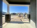 Covered front porch with stone columns and desert landscaping around the home during the construction phase at 22669 E Saddle Way, Queen Creek, AZ 85142