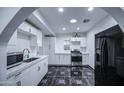 Modern kitchen with white cabinets, stainless steel appliances, and stylish tile flooring at 2430 W Papago St, Phoenix, AZ 85009