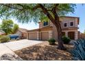 Charming two-story home with a spacious driveway, three-car garage, and mature tree at 2918 E Silverbell Rd, San Tan Valley, AZ 85143