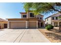 Inviting two-story home with a spacious three-car garage, long driveway, and a lovely tree at 2918 E Silverbell Rd, San Tan Valley, AZ 85143