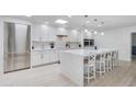 Modern white kitchen featuring a large island with bar seating, stainless steel appliances, and ample cabinet space at 3038 E Stella Ln, Phoenix, AZ 85016