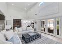 Open-concept living room with high ceilings, neutral decor, and a glimpse into the modern, white kitchen at 3038 E Stella Ln, Phoenix, AZ 85016