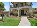 Charming two-story home features a cozy balcony, arched entryway, lush landscaping, and inviting curb appeal at 3042 N Beverly Pl, Buckeye, AZ 85396