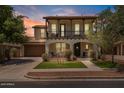 Charming two-story home features a cozy balcony, arched entryway, lush landscaping, and inviting curb appeal at 3042 N Beverly Pl, Buckeye, AZ 85396