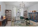 Well-lit home office with modern decor, ample workspace, a decorative rug, and a stylish chandelier at 3042 N Beverly Pl, Buckeye, AZ 85396