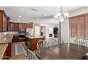 Eat-in kitchen with stainless appliances, granite counters, island, and dark wood cabinetry at 3177 S Sierra St, Gilbert, AZ 85295