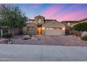 Exterior view of a two-story home featuring neutral tones, desert landscaping, brick driveway, and two car garage at 32359 N 129Th Dr, Peoria, AZ 85383