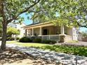 Inviting single-Gathering home with a covered porch and lush green lawn, surrounded by mature trees at 3765 N Denny Way, Buckeye, AZ 85396