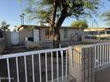 Charming home exterior featuring a cozy yard space with a shade tree, enclosed by a classic white fence at 3946 W Holly St, Phoenix, AZ 85009