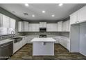 Modern kitchen featuring white cabinetry, stainless steel appliances, and center island at 41581 W Somerset Dr, Maricopa, AZ 85138
