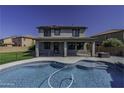 Backyard view of pool and covered patio with solar panels on roof at 41581 W Somerset Dr, Maricopa, AZ 85138