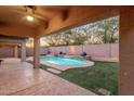 Outdoor patio showcasing a pool with a waterfall feature and artificial turf landscaping at 4208 E Hamblin Dr, Phoenix, AZ 85050