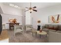 Bright living room featuring neutral furniture, a ceiling fan, and an open dining area bathed in natural light from the skylight at 4406 E Carter Dr, Phoenix, AZ 85042