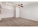 Bright, spacious living room featuring neutral carpeting, a ceiling fan, and natural light at 4406 E Carter Dr, Phoenix, AZ 85042
