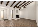 Bright living room with high ceilings, wood beams, fireplace, and wood-look floors at 4722 W Via Cynthia --, Glendale, AZ 85301