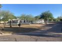 A single-story home featuring desert landscaping, mature trees, and a low privacy wall at 7044 E Ann Way, Scottsdale, AZ 85254