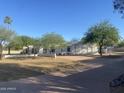 Charming single-story home featuring desert landscaping, mature trees, and a low privacy wall at 7044 E Ann Way, Scottsdale, AZ 85254