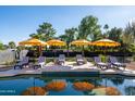 Relax by the pool with striped lounge chairs and bright yellow umbrellas for a perfect outdoor getaway at 8001 E Voltaire Ave, Scottsdale, AZ 85260