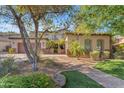 Charming home with arched windows, well-manicured lawn, and desert landscaping in a peaceful setting at 824 W Whitten St, Chandler, AZ 85225