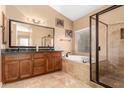Well-lit bathroom featuring dual sinks, granite counters, a soaking tub and a glass enclosed shower at 882 N Concord Ave, Chandler, AZ 85225