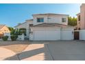 Charming two-story white stucco home with a tile roof and spacious driveway at 13 W Silverwood Dr, Phoenix, AZ 85045