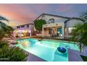 Beautiful backyard with a sparkling pool, covered patio and relaxing lounge area at 13636 W Calavar Rd, Surprise, AZ 85379