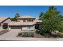 Inviting two-story home with a tile roof, attached garage, desert landscaping, and mature palm trees at 14609 S 24Th Way, Phoenix, AZ 85048