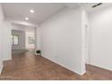 Bright hallway with tile floors leading to an open living area at 15674 W Mackenzie Dr, Goodyear, AZ 85395