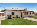 Well-maintained home with green lawn, white brick exterior, and a cozy covered porch at 162 N Hunt W Dr, Mesa, AZ 85203